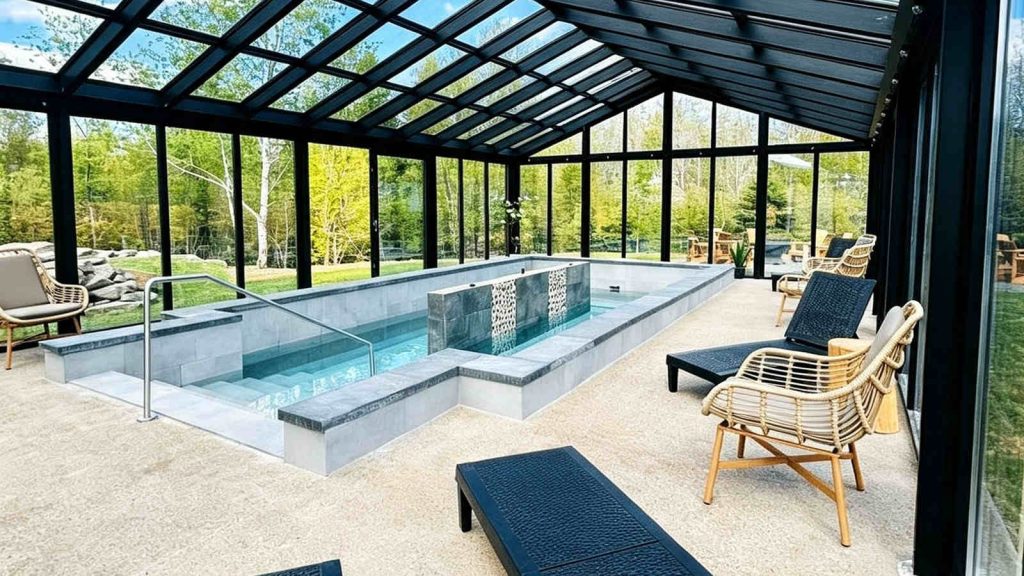Minimalist pool sunroom with wicker lounge chairs and stone deck.